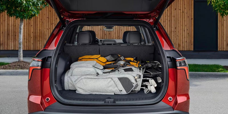 Open car trunk with golf bag and duffel bag.