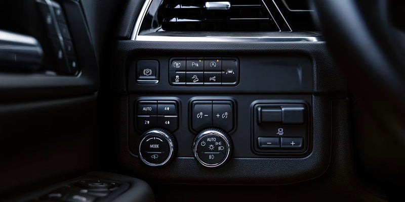 
Vehicle dashboard controls including parking brake, four-wheel drive, and lighting switches.
