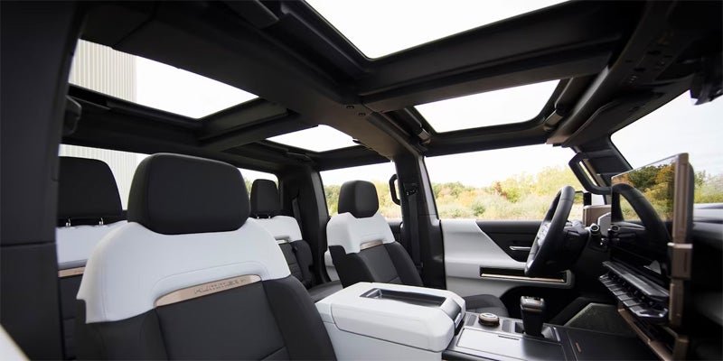 
GMC Hummer EV interior showing white and black seats and four removable roof panels.